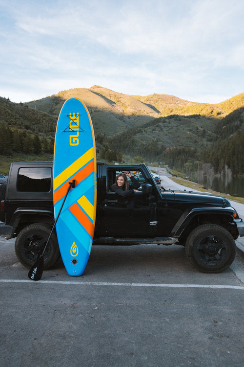 paddle board against a jeep