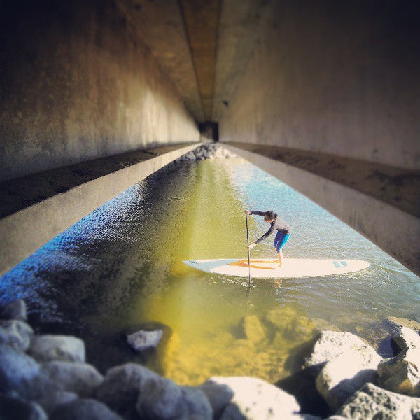 paddle board under a bridge