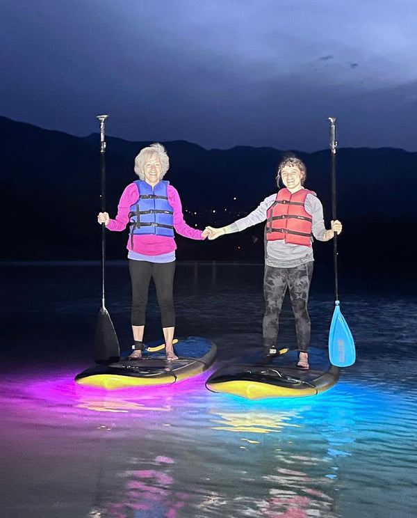 woman on paddle boards at night