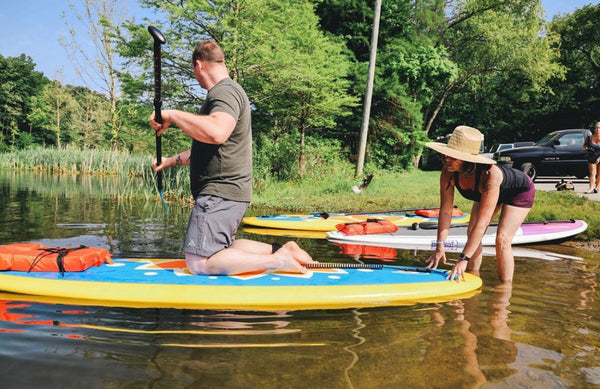 man kneeling on paddleboard